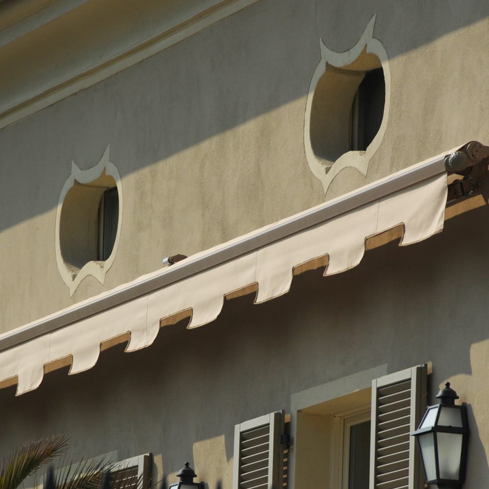 Esterno edificio con tenda a bracci estensibili bianca